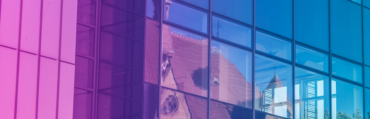 A reflection of the John Owens building in to window of the Alan Gilbert Learning Commons